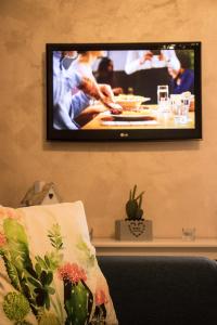 a flat screen tv hanging on a wall with a couch at Peter's House in Letojanni