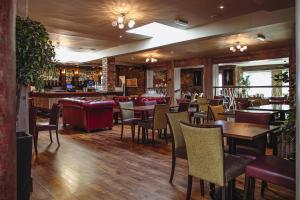a restaurant with tables and chairs and a bar at Muskerry Arms Bar and B&B in Blarney