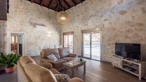 a living room with a couch and a tv at Casa El Hoyillo El Gastor by Ruralidays in El Gastor