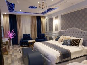 a bedroom with a large bed and two chairs at شقق جوهرة الأماكن للشقق المخدومة - أقتصادي in Taymāʼ