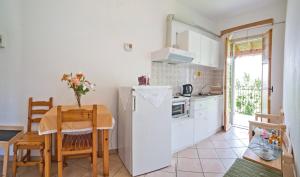 a kitchen with a table and a white refrigerator at Villa Rebecca in Agios Gordios