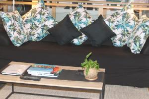 a black couch with pillows and a coffee table at SEAVIEWS Oak Beach in Oak Beach
