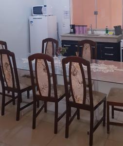 cocina con mesa con 4 sillas y nevera en Sobrado 2 amplo e confortável em condomínio en Corumbá