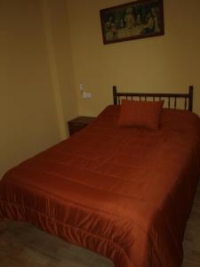 a bed with a red comforter in a bedroom at San Antón in Cazorla