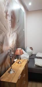 a bedroom with a painting of a woman on the wall at Apartamenty PRETTY WOMAN self check-in 24h - Bytom Chorzów Katowice in Bytom