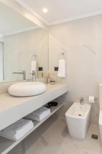 Baño blanco con lavabo y aseo en Hotel Solerios, en Punta del Este