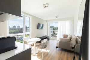 a kitchen and living room with a table and chairs at Hotel Solerios in Punta del Este