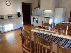 a kitchen with white appliances and a table and chairs at Gramersgården in Söderala