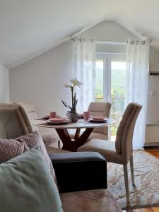a living room with a table and chairs and a window at AS Delux Apartmani in Soko Banja