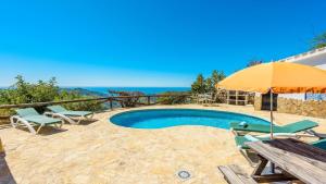 einen Pool mit Sonnenschirm, Tisch und Stühlen in der Unterkunft Finca Algarabia Competa by Ruralidays in Cómpeta