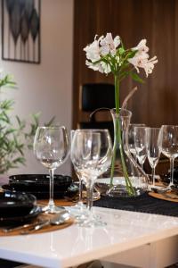 einen Tisch mit Weingläsern und eine Vase mit Blumen in der Unterkunft Smart Executive in Krakau
