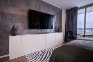 ein Schlafzimmer mit einem großen weißen Schrank mit einem TV darauf in der Unterkunft RüSuite II - Gemütliches Apartment in Rüttenscheid in Essen