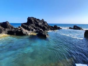 an image of the ocean with rocks in the water at QVA - Quinta Velha das Amoreiras in Vila Franca do Campo