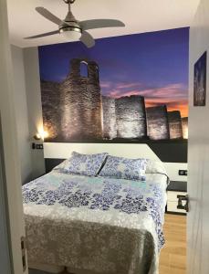 a bedroom with a castle mural on the wall at Suite Lugo in Úbeda