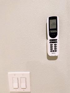 Temple Cityにある华人区花园别墅のコンセントの横の壁に掛けられた携帯電話