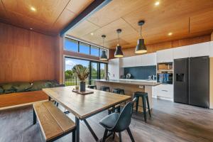 a kitchen and dining room with a table and chairs at Kapiti Heights - Ōtaki Beach Holiday Home in Otaki Beach