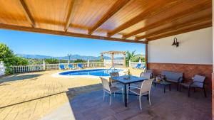 un patio con mesa, sillas y piscina en Villa Galiano Alhaurin de la Torre by Ruralidays, en Alhaurín de la Torre