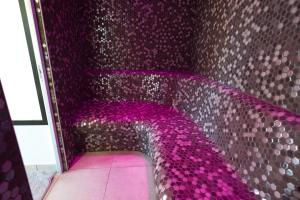 a purple room with a purple wall with a purple couch at Ferme Historique Jean De La Fontaine et ses chambres d'hôtes Hammam-Spa - 4 étoiles in Chierry