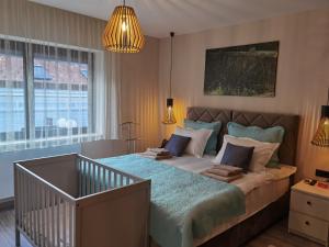 una camera da letto con un letto grande e un lampadario di Rustica Nocte Boutique Apartments a Požega