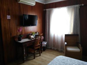 a room with a desk and a television and a bed at HOSPEDAJE TU SITIO in La Esperanza