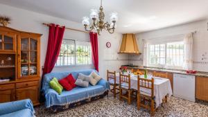 sala de estar con sofá azul y cocina en Casa Alejo Antequera - La Higuera by Ruralidays, en Antequera