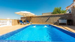 - une piscine avec une terrasse et un parasol dans l'établissement Casa Medina Guevejar by Ruralidays, à Güevéjar