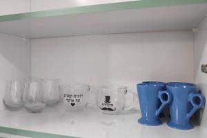 ベエルシェバにあるCentrally-located Quiet Cozy Loft apartmentの棚(カップなどガラス製品付)