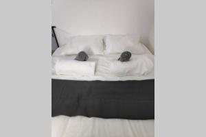 Una cama blanca con dos almohadas encima. en Centrally-located Quiet Cozy Loft apartment, en Beer Sheva