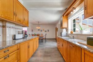 a kitchen with wooden cabinets and a counter top at Holiday home in Ribamar - Lissabon Region 42000 in Ribamar