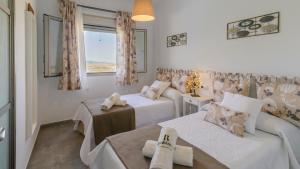 salon z dwoma łóżkami i oknem w obiekcie Casa Jacaranda El Gastor by Ruralidays w mieście El Gastor