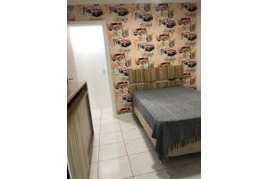 - une chambre avec un lit et un mur recouvert d'un papier peint de course dans l'établissement Apartamento Frente Mar Meia Praia, à Itapema
