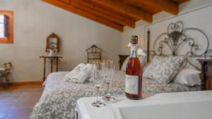 una botella de vino sentada en una mesa con dos copas de vino en Casa Rural Malaga Spa Cartama by Ruralidays, en Cártama