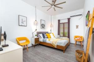 a bedroom with a bed and two orange chairs at Villa Chica 3 min to Beach, Diving & Restaurants with Pool and private Garden 10 min to Windsurfing & Kitesurfing in Belnem +33 photos