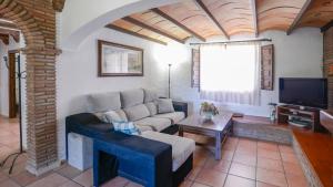 a living room with a couch and a tv at Cortijo Alejandro Malaga - Campanillas by Ruralidays in Málaga