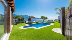 einen Hinterhof mit Pool und grünem Gras in der Unterkunft Villa Belen Torrox by Ruralidays in Torrox
