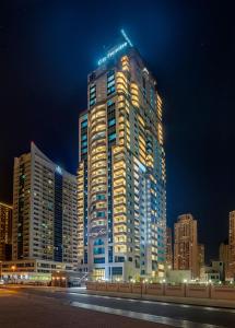 een hoog gebouw met 's nachts lichten erop bij City Premiere Marina Hotel Apartments in Dubai