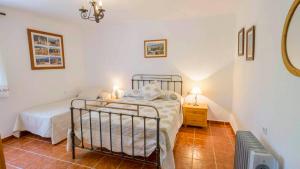 a small bedroom with a bed and a night stand at Cortijo La Monja Antequera - La Higuera by Ruralidays in Antequera +16 photos