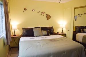 a bedroom with a bed and two lamps and a mirror at Kihei Kai Nani 161 in Kihei +11 photos