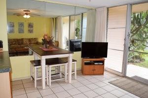 a living room with a table and a television at Kihei Kai Nani 161 in Kihei