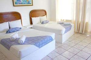 two beds in a room with blue and white at Hotel Ameyali Tequesquitengo in Tequesquitengo