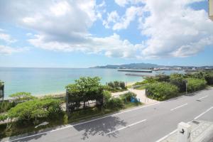 a view of the ocean from a street at Beach side hotel YAMORIYANONIKAI J29 in Nago