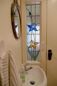 Pierrepoint Accommodation في هاميلتون: حمام مع حوض ونافذة زجاجية ملطخة