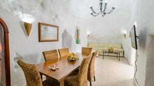 a dining room with a wooden table and chairs at Cuevas El Mirador Pozo Alcon by Ruralidays in Pozo Alcón