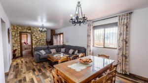 uma sala de estar com uma mesa e um sofá em Villa Fraskito Iznajar by Ruralidays em Iznájar