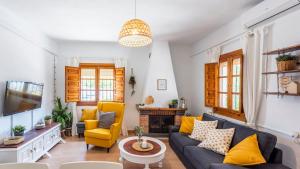 a living room with a blue couch and yellow chairs at El Llano del Torcal Antequera - La Higuera by Ruralidays in Antequera