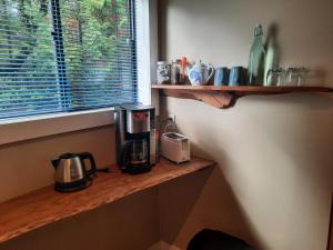 a coffee maker on a wooden shelf next to a window at Beaver Hut Bed And Breakfast in Port Alberni +29 photos