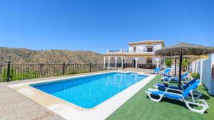 uma casa com uma piscina com cadeiras e um guarda-sol em Villa Jazmin Vinuela by Ruralidays em Viñuela