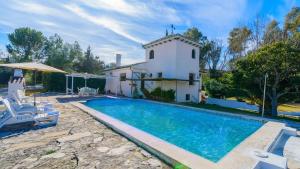 a villa with a swimming pool in front of a house at Casa El Rosario Ronda by Ruralidays in Ronda