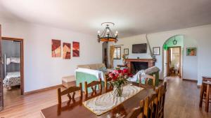 ein Wohnzimmer mit einem Tisch, Stühlen und einem Kamin in der Unterkunft Casa El Parque de Isabel Prado del Rey by Ruralidays in Prado del Rey