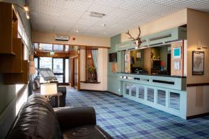 a living room with a couch and a kitchen at The Caledonian Claymore Hotel in Arrochar